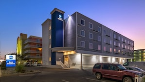 A Best Western hotel with a modern design, multiple floors, and a parking area with cars. - Best Western Ocean City Hotel & Suites (Ocean City)
