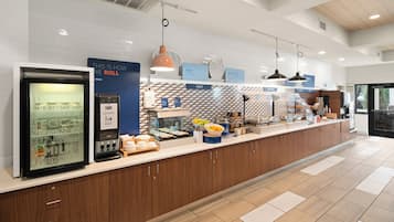 A modern breakfast bar with a refrigerated display, a self-serve yogurt station, and a variety of breakfast items.