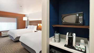A hotel room with two beds, a minibar, a microwave, and a coffee maker.