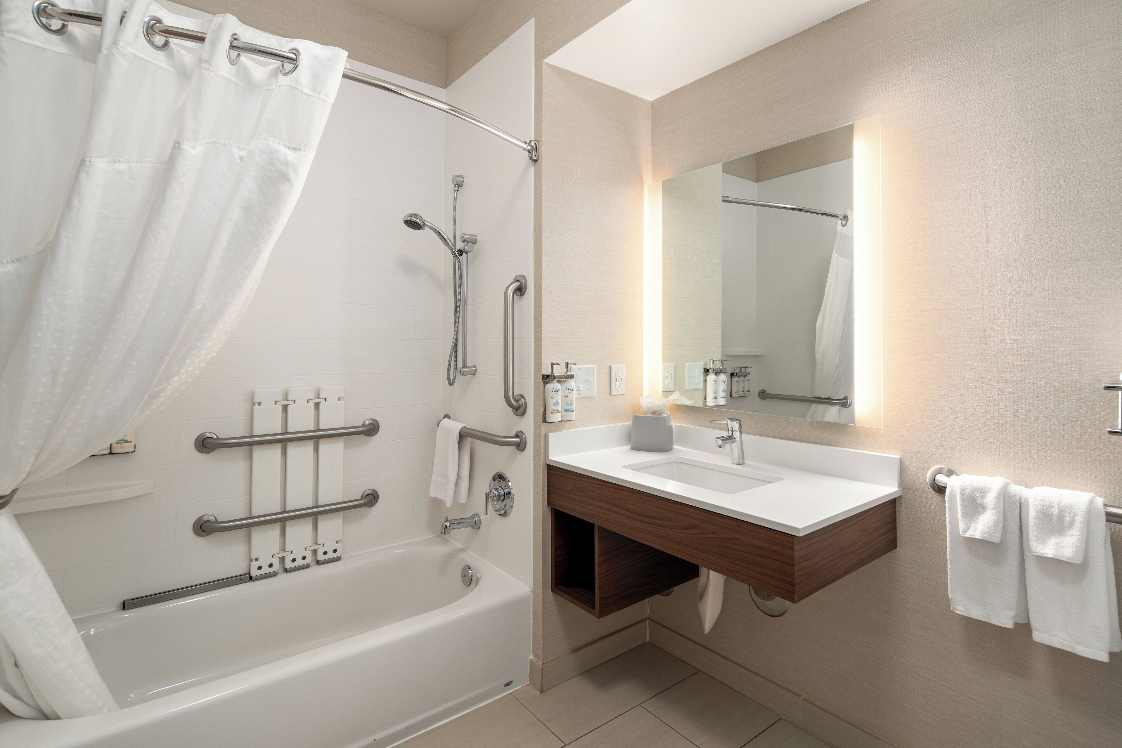 A modern bathroom with a bathtub, shower, and vanity.