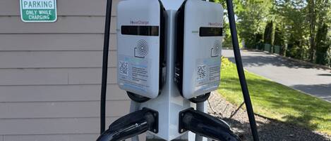 An electric vehicle charging station with a sign indicating it's for electric vehicle parking only while charging.