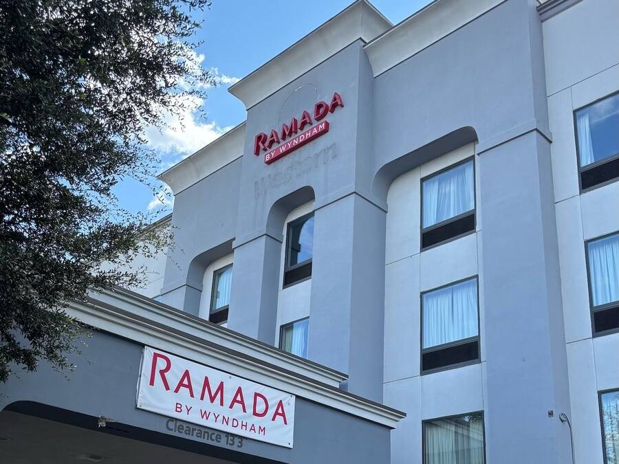 A modern building with a sign reading "RAMADA BY WYNDHAM" and "Clearance 133".
