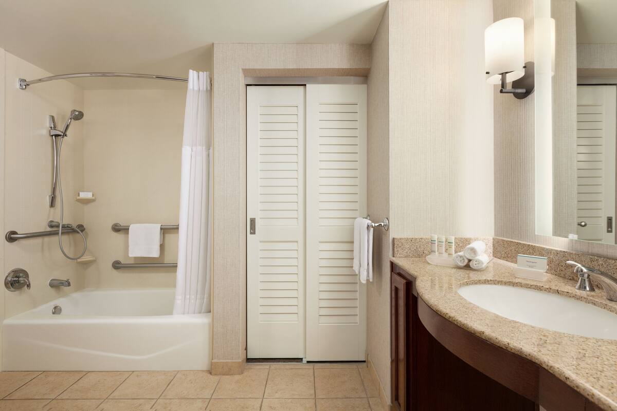 Une salle de bain moderne équipée d’une baignoire, d’une douche et d’un meuble-lavabo avec un évier.