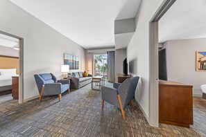 Une chambre d’hôtel avec un lit, un canapé, une télévision et un bureau.