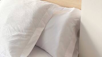 A bed with white bedding and a wooden headboard.