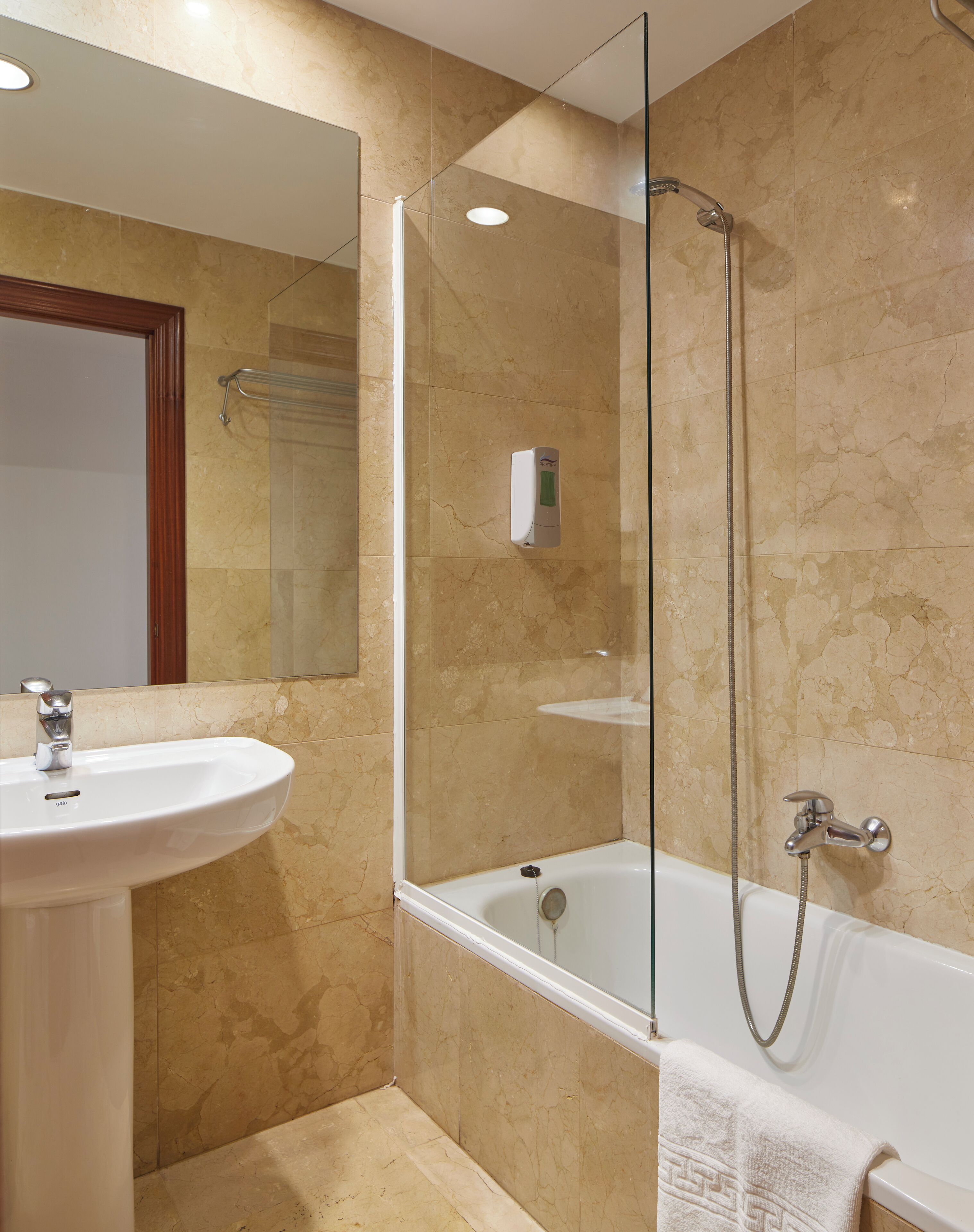 A bathroom with a sink, mirror, shower, and bathtub.