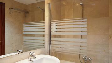 A bathroom with a white sink, a mirror, a shower, and a towel rack.
