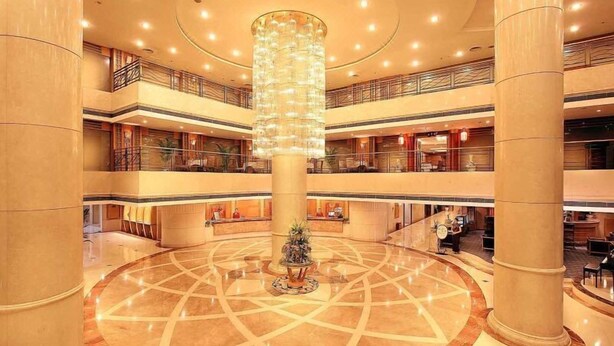 A multi-level hotel lobby with a central circular area, multiple floors, and a large chandelier. - Green Land Hotel - Chengdu (Chengdu)
