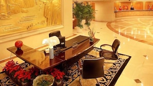A reception area with a reception desk, chairs, and a large decorative wall. - Green Land Hotel - Chengdu (Chengdu)