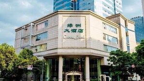 A hotel with a prominent sign in a foreign language, surrounded by modern buildings and trees. - Green Land Hotel - Chengdu (Chengdu)