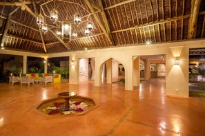 An indoor atrium with a high ceiling, decorative lanterns, a central water feature, and a seating area with cushions. - Neptune Paradise Beach Resort & Spa (Diani Beach)
