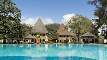 Una piscina al aire libre, sombrillas, sillones reclinables de piscina