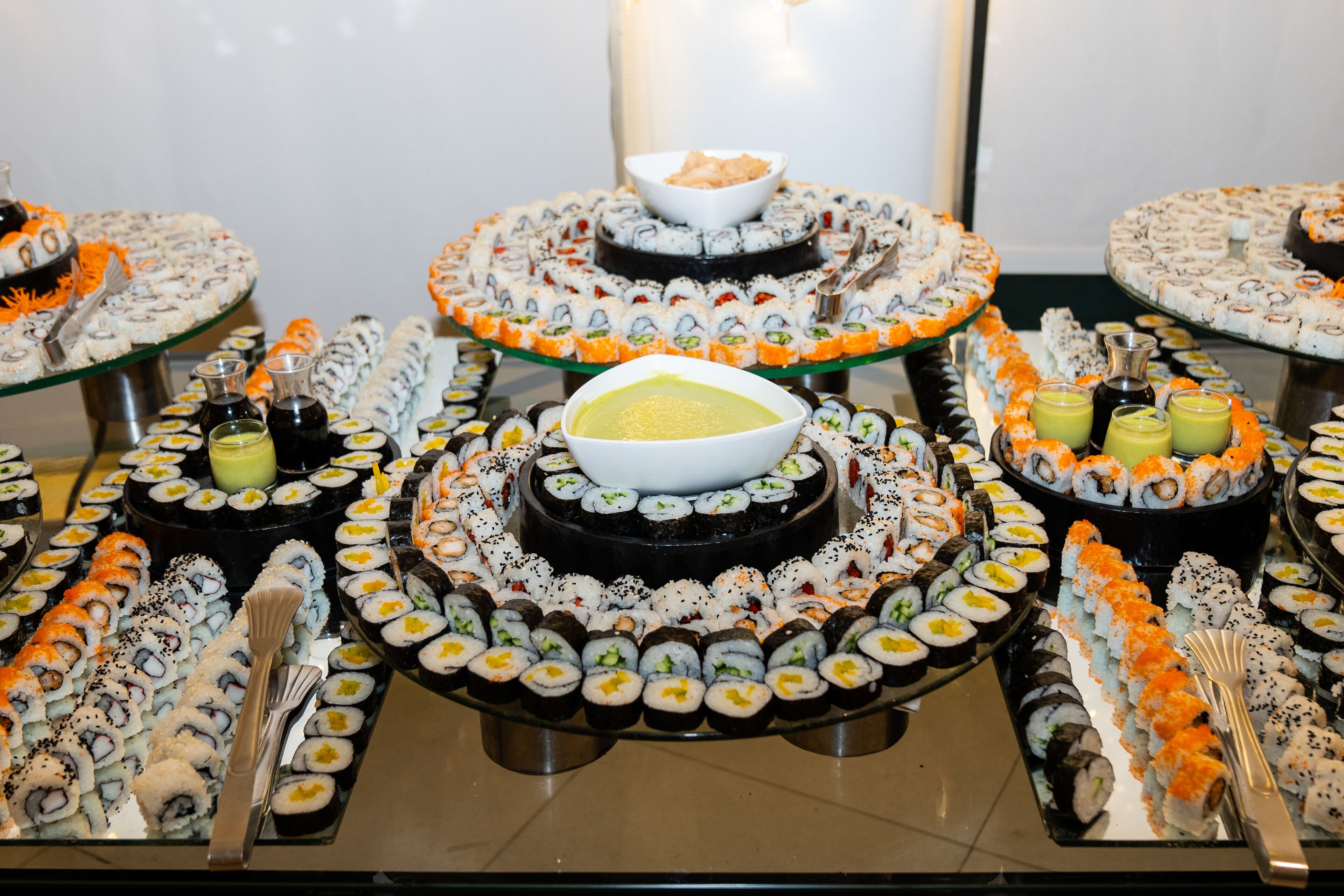 Ein Buffet mit verschiedenen Sushi-Platten und einer Suppenschüssel.
