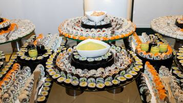 Ein Buffet mit verschiedenen Sushi-Platten und einer Suppenschüssel.