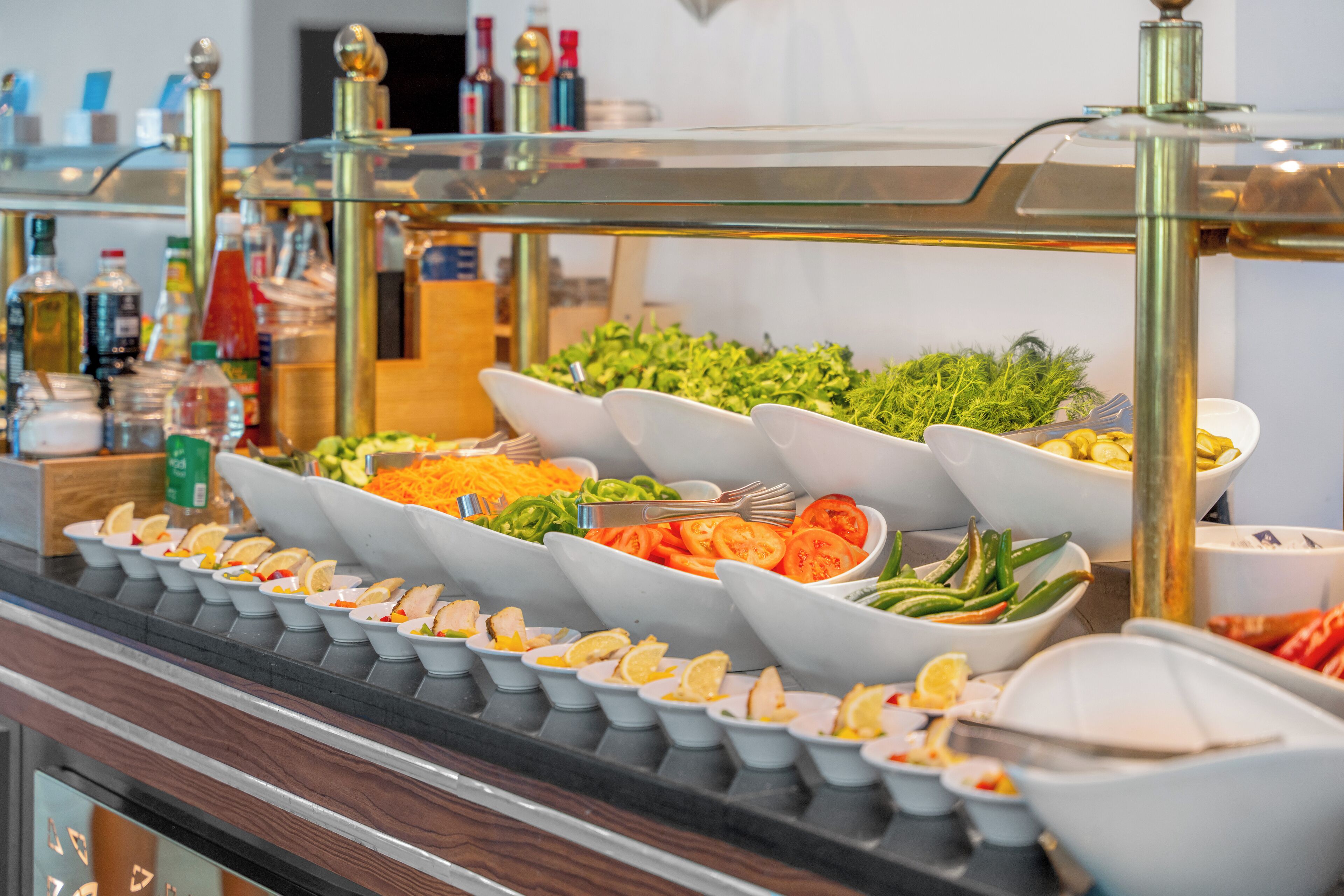 A buffet with various food items including salads, vegetables, and sliced meats.