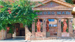 Fachada de un edificio con el nombre "CHOROMAR" y estatuas de mujeres.