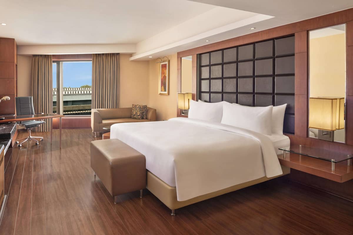 Un moderno cuarto de hotel con una cama grande, un escritorio y vistas a la ciudad.