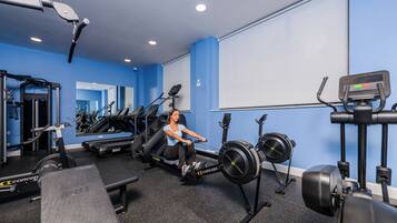 A gym with a rowing machine, treadmills, and weight machines.