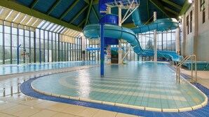 An indoor swimming pool with a blue water slide and a lifeguard station. - China Fleet Country Club (Saltash)