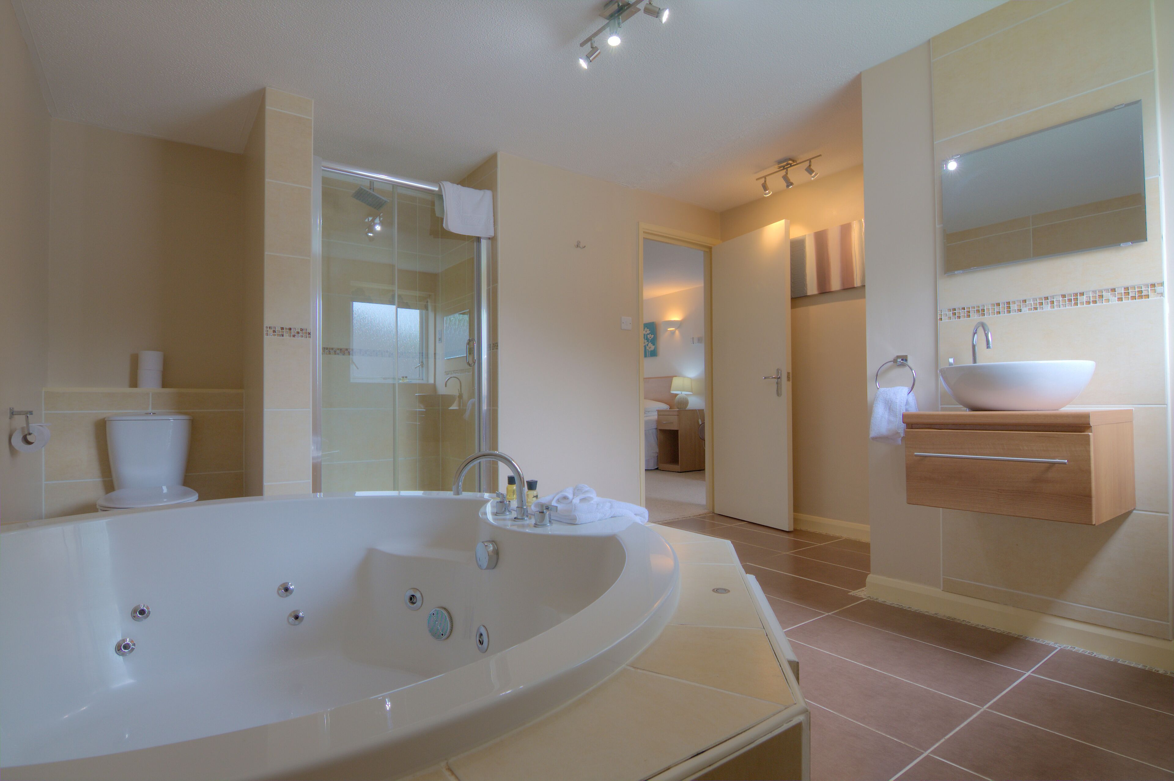 A spacious bathroom with a large bathtub, a separate shower area, and a vanity with a sink.
