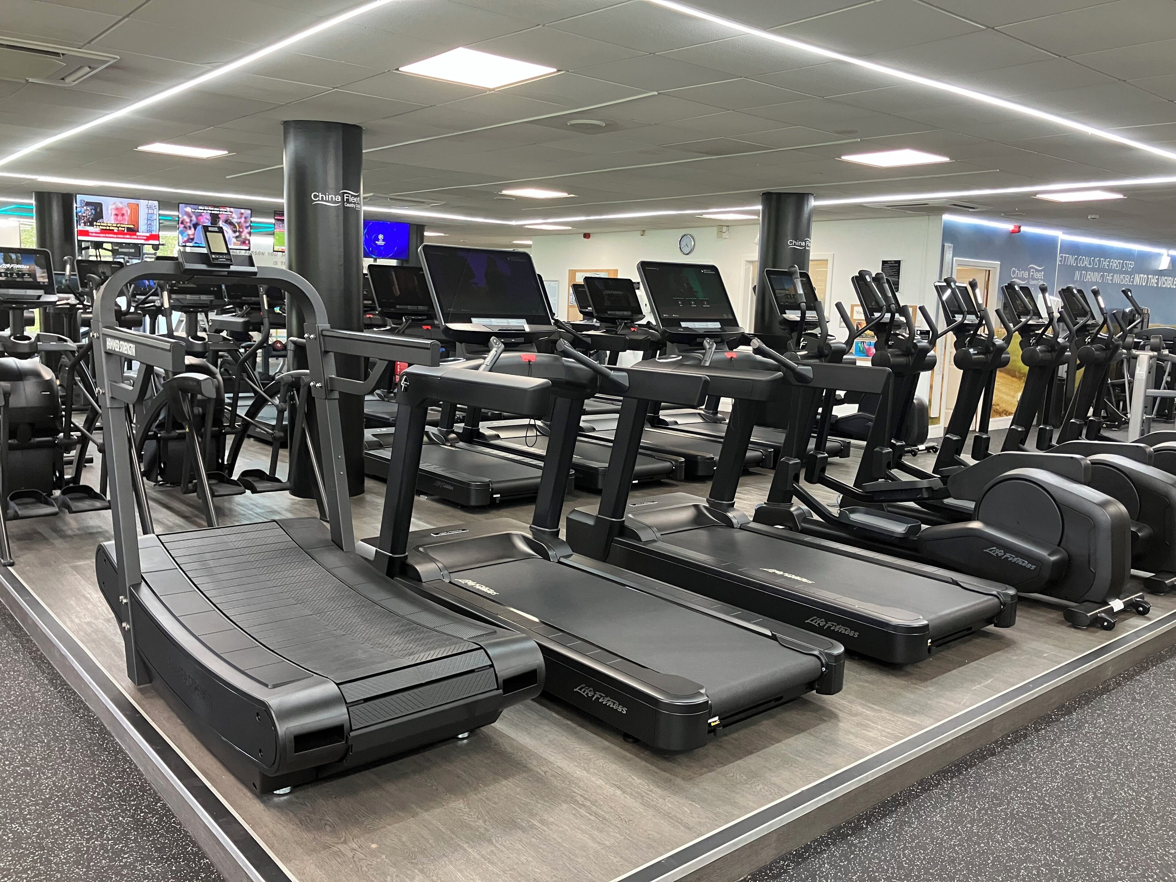 Et fitnesscenter med løbebånd, crosstrainere og styrkemaskiner.