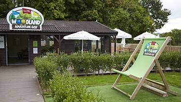 A golf course with a wooden clubhouse and a green chair.