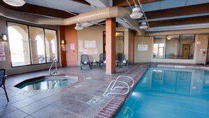 An indoor swimming pool with clear poolside areas, safety signs, and seating arrangements. - Drury Inn & Suites Amarillo (Amarillo)