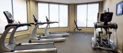 A fitness room with treadmills and an elliptical machine.