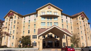 A multi-story hotel with a prominent entrance, multiple balconies, and a clear blue sky. - Drury Inn & Suites Amarillo (Amarillo)