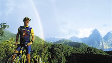 A cyclist on a mountain bike with a rainbow in the background.