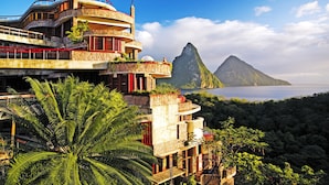A multi-level building with balconies overlooking a mountainous landscape and a body of water. - Jade Mountain Resort (Soufrière)