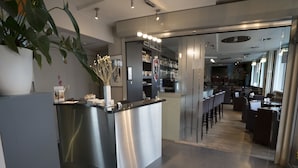 A modern reception area with a bar and seating. - Hotel Orchidee (Aalter)