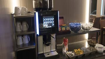 Un espace dédié au café, équipé d’une machine à café, de tasses et de divers condiments.
