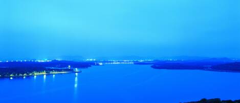 Une vue nocturne d’une rivière, les lumières de la ville se reflétant sur l’eau.