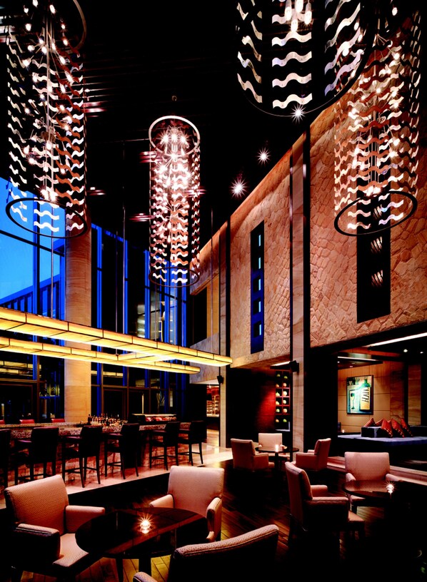A modern interior with high ceilings, hanging light fixtures, and a bar area. - Hyatt Regency Dongguan (Dongguan)