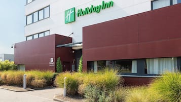 A Holiday Inn building with a modern facade, large windows, and a visible entrance.