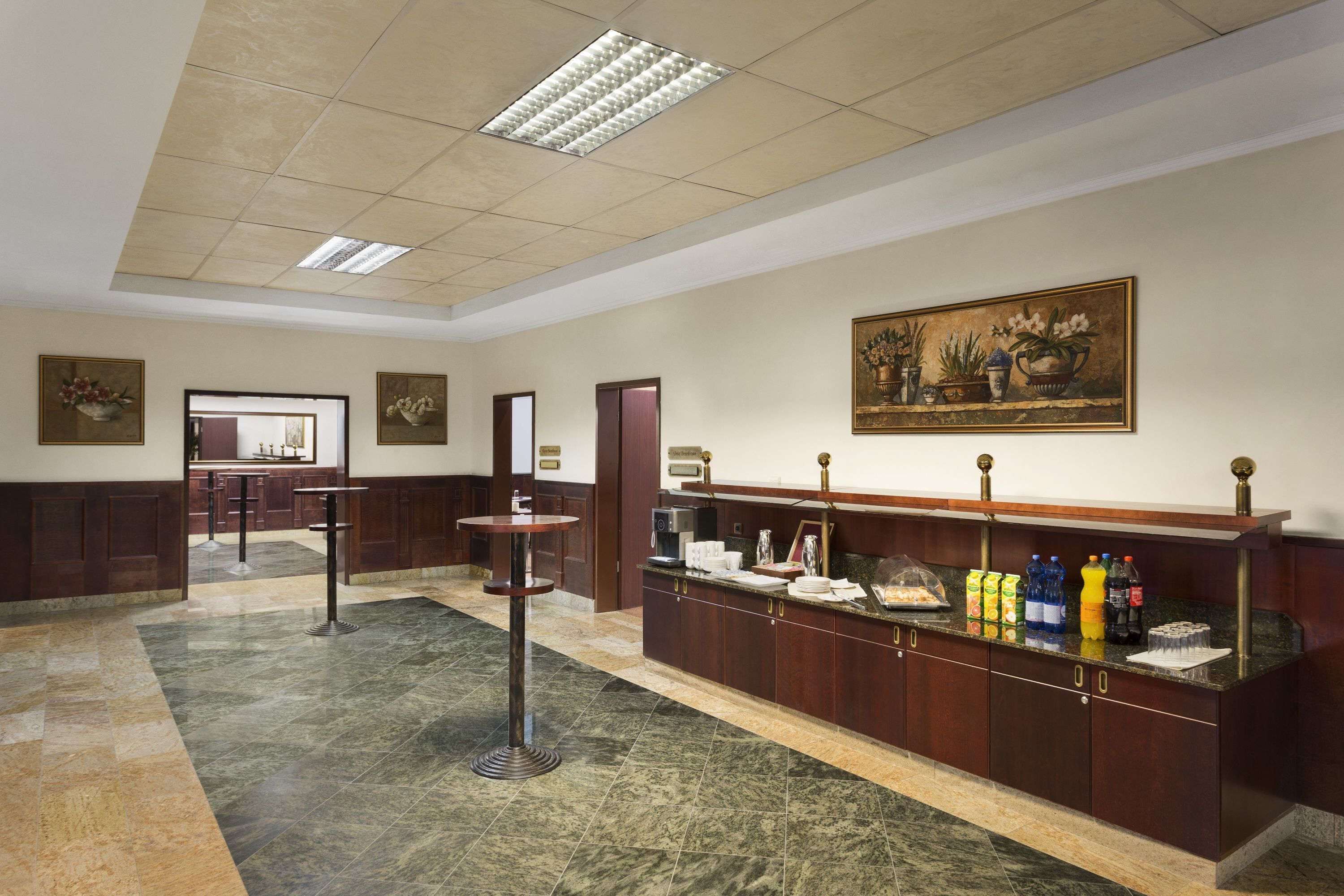 A lobby with a reception desk, a coffee station, and artwork on the walls.