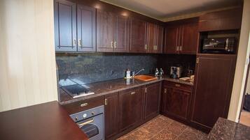 Una cocina moderna con armarios de madera oscura, encimera de granito y electrodomésticos de acero inoxidable.