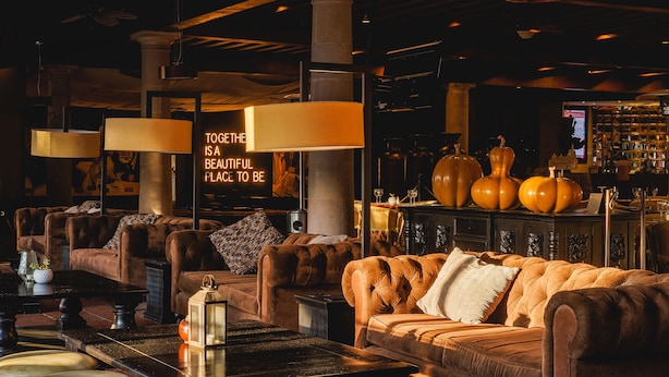 A cozy lounge area with leather sofas, a bar with bottles, and a neon sign. - Real de Minas San Miguel de Allende (San Miguel de Allende)