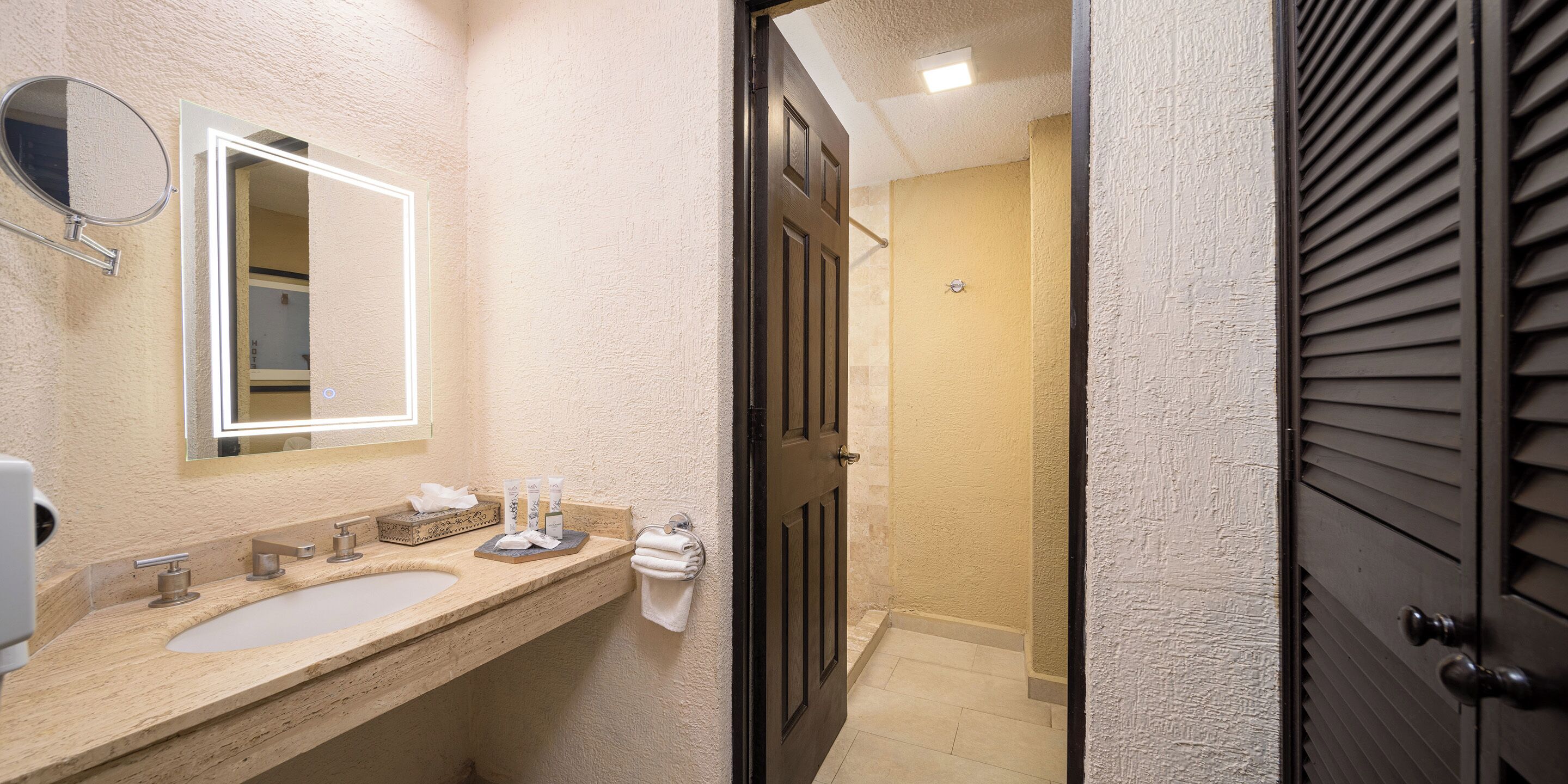 Un baño con lavabo, espejo y toallero.