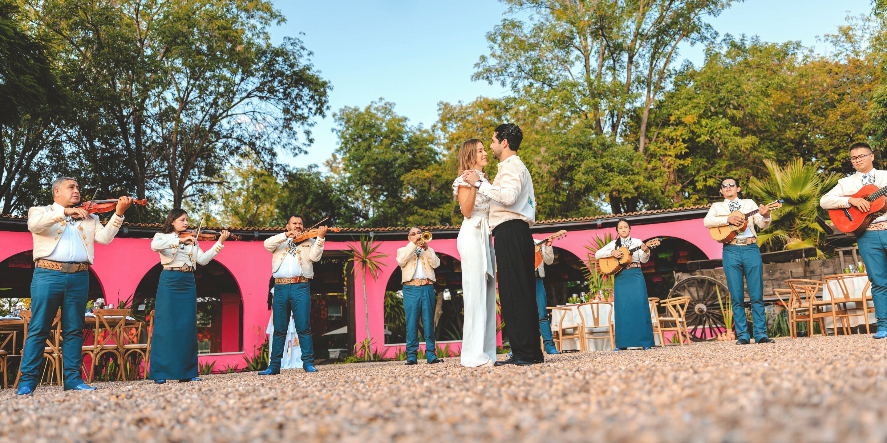 A group of musicians performing outdoors with a building in the background.