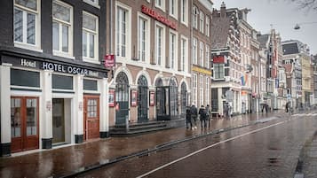 Een straat met gebouwen, waaronder Hotel Oscar en Hotel Kleinere.