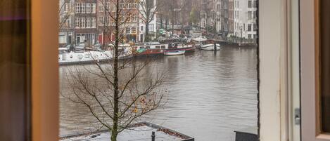 A view from a window overlooking a river with buildings and boats.