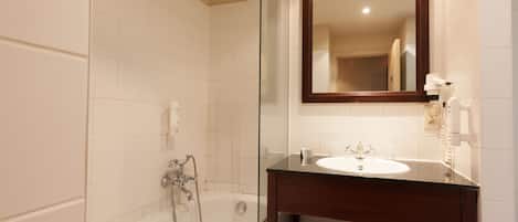 Un baño con bañera, lavabo y espejo.