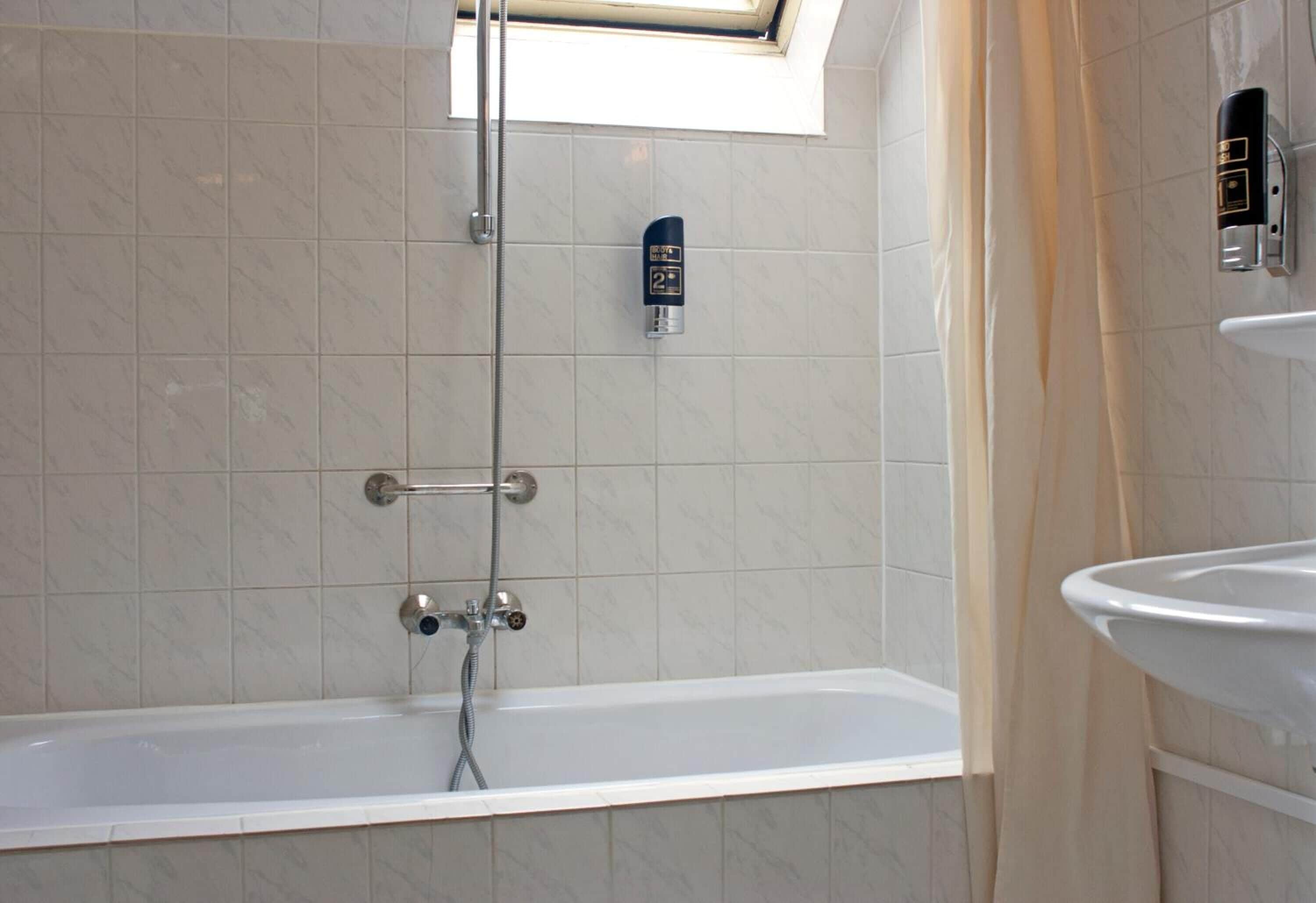 Une salle de bain avec une baignoire, une douche et des toilettes.