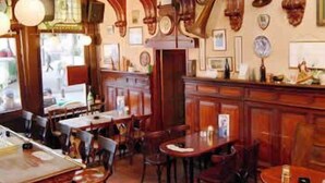 Ein traditionelles Interieur mit Holzmöbeln, einer Bar und verschiedenen Wanddekorationen.