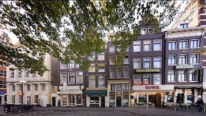 Eine Reihe von Gebäuden, an denen Schilder mit 'PRINS HENDRIK HOTEL' und 'Hotel' angebracht sind, was auf ein Hotel hinweist.