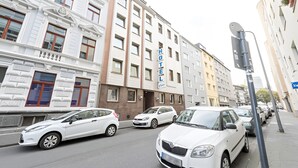 Un hotel con fachada clásica, múltiples ventanas y un llamativo letrero que dice 'HOTEL'.