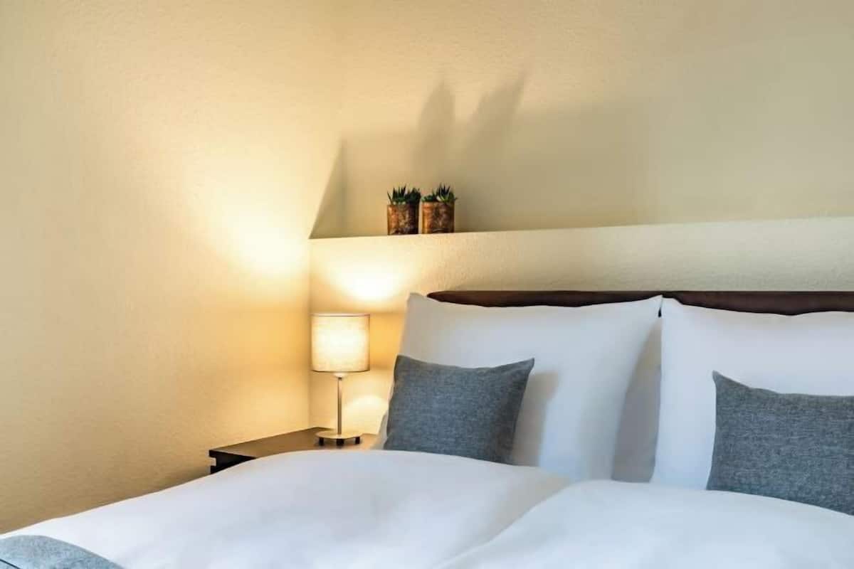 Ropa de cama hipoalergénica y caja de seguridad en la habitación