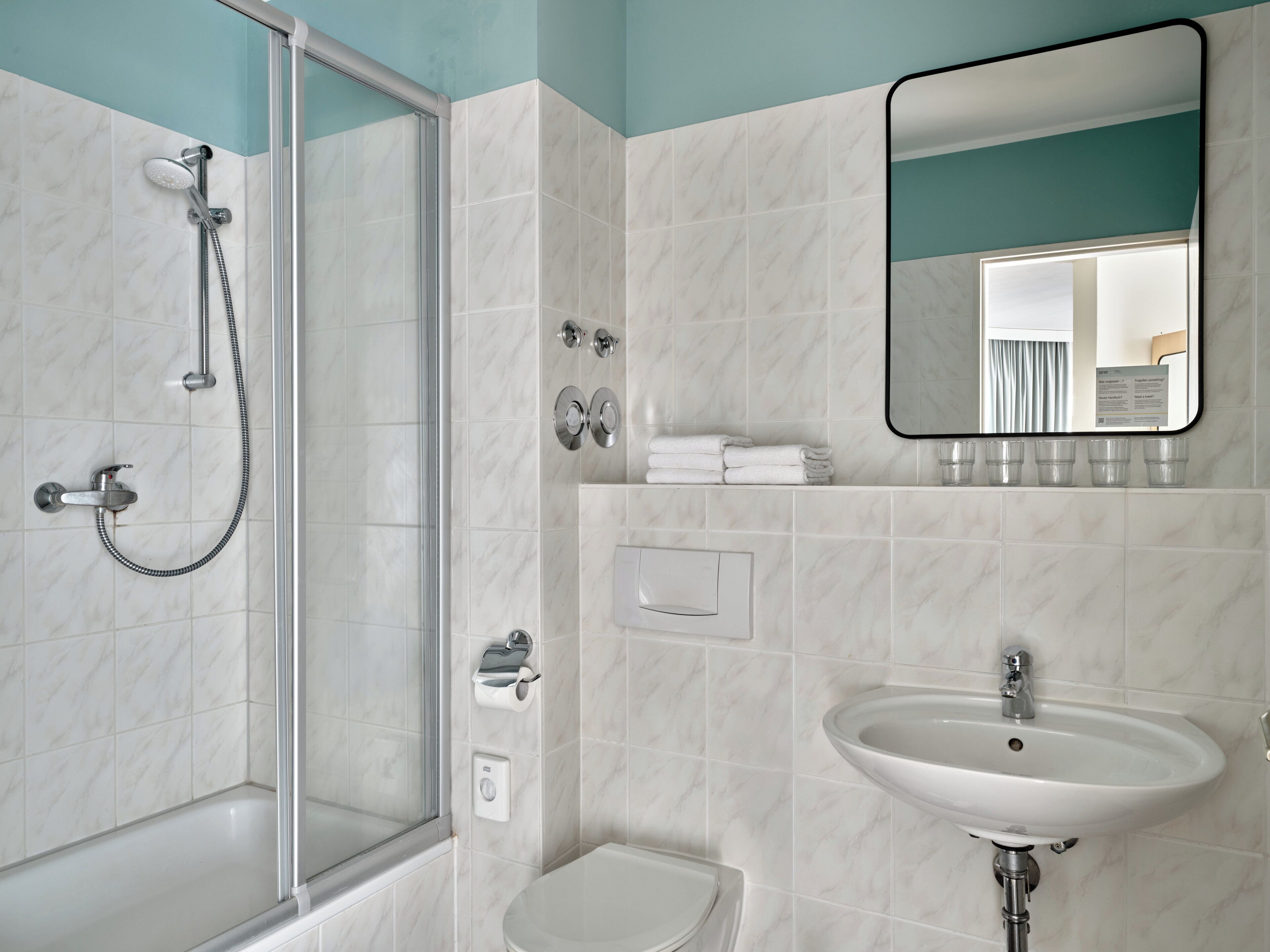 Une salle de bain avec une douche à parois de verre, un lavabo et des toilettes.